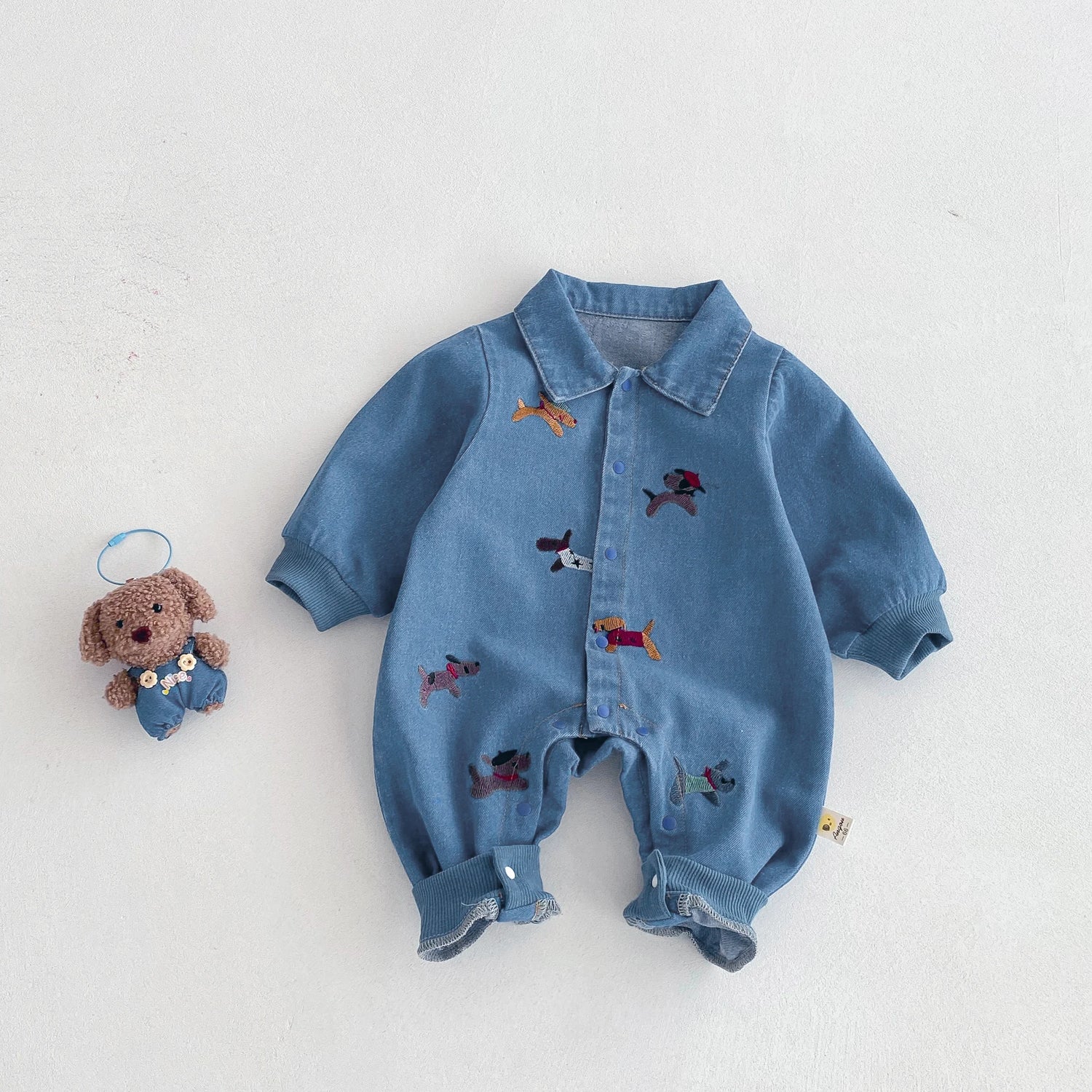 Blue denim baby romper with embroidered designs 