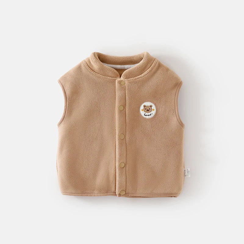 Beige children's vest with a bear emblem on it