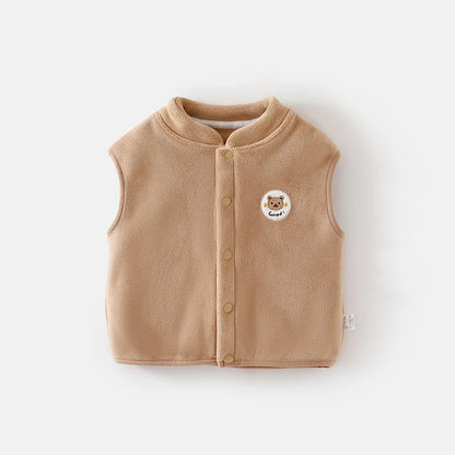 Beige children's vest with a bear emblem on it